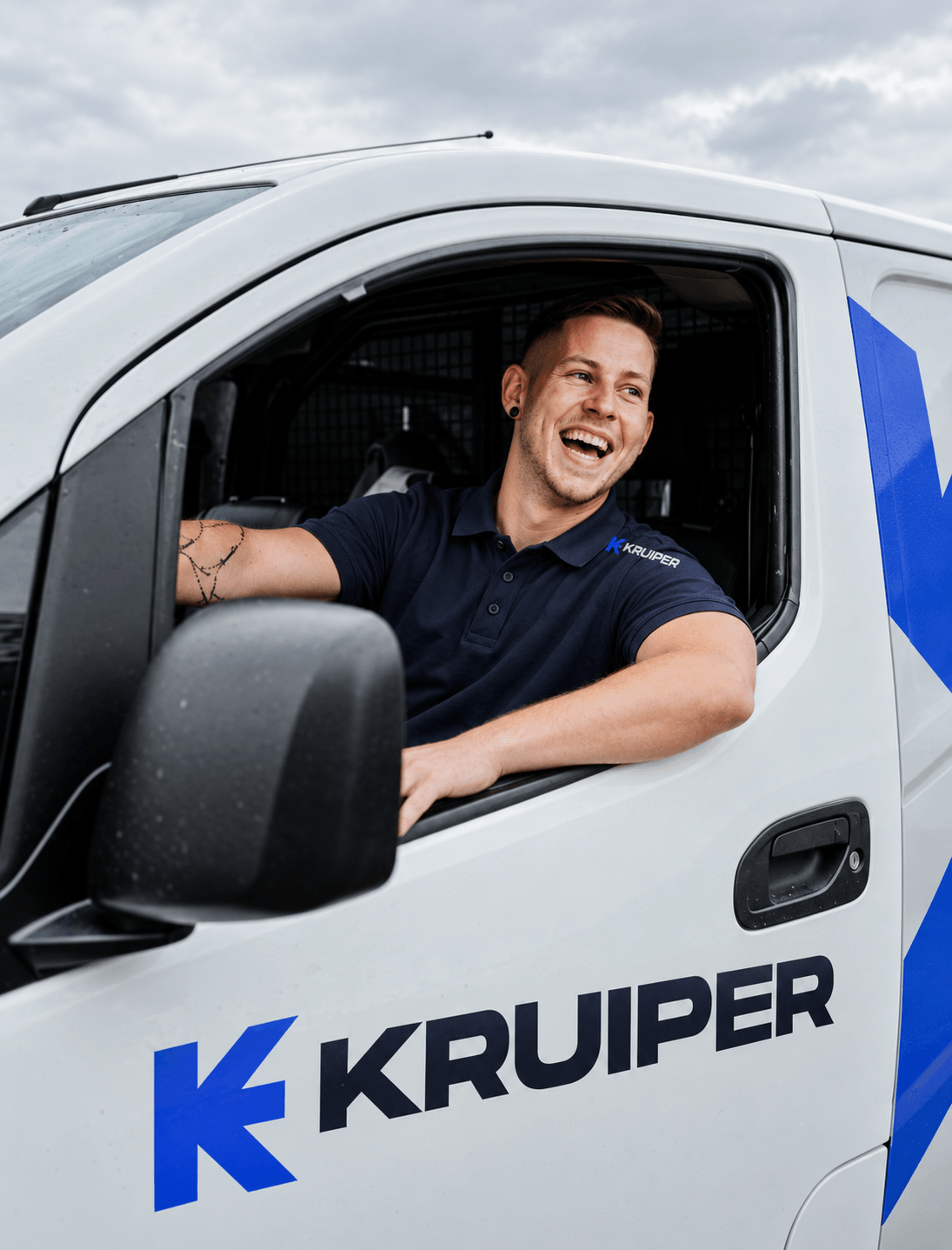 Lachende monteur van Kruiper in een bedrijfsbus